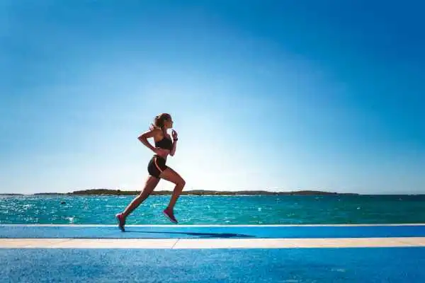 Woman running showing strong leg muscle Olney